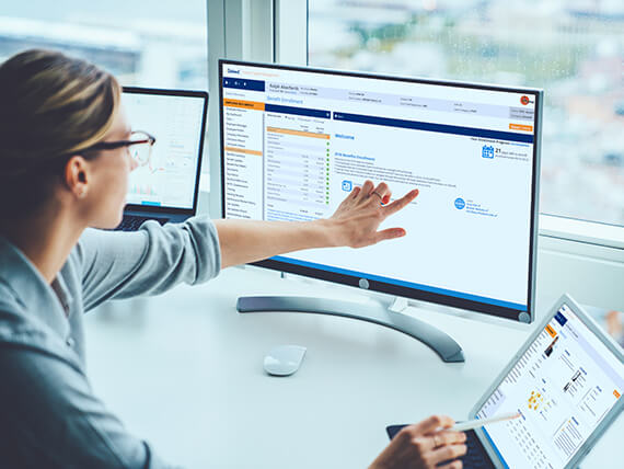 Businesswoman pointing and reviewing laptop and desktop screens